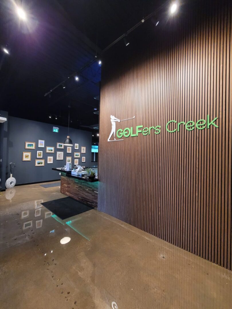 The logo of a golfers creek on a wood wall